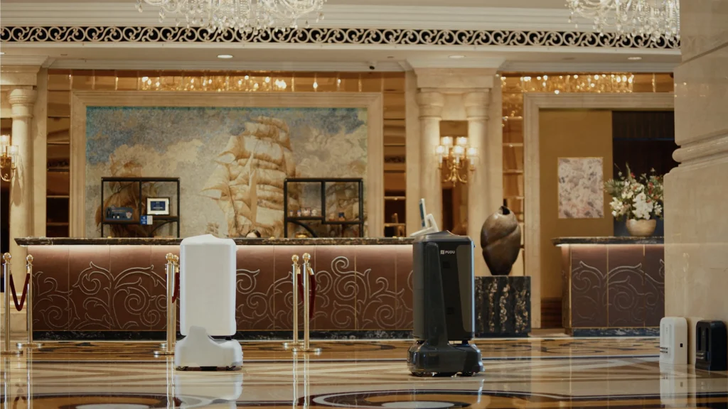 Two Pudu robots in a hotel lobby.